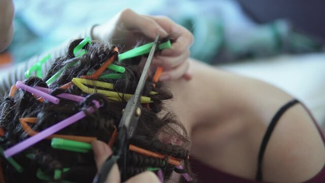 Girls make a curly hair at home with plastic straws