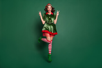 Full length body size view of pretty trendy cheerful girl jumping showing v-sign isolated over...