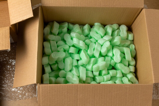 Cardboard box filled with green styrofoam granules
