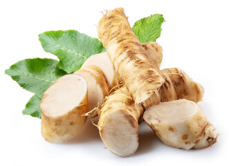 Horseradish roots and green leaves close up on the white background.