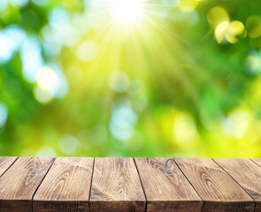 Bokeh sunny nature background and wood board in foreground. File contains board clipping path. It...