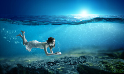 Naklejka premium Woman holding a cup underwater
