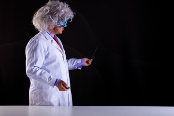 Crazy science teacher in white coat with unkempt hair in funny eye glasses
