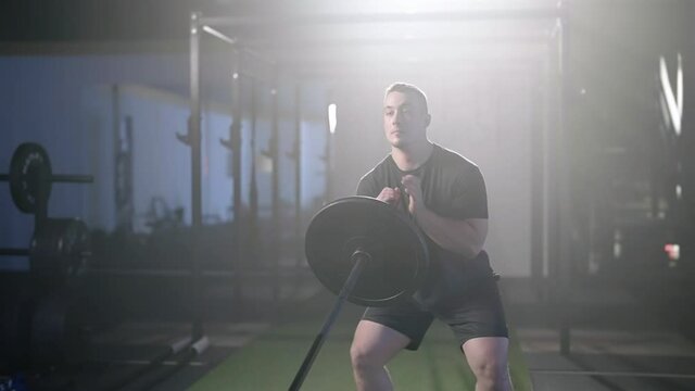 Fitness guy train snatch balance with barbell under spotlight in gym 4K