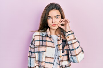 Young caucasian girl wearing casual clothes mouth and lips shut as zip with fingers. secret and...