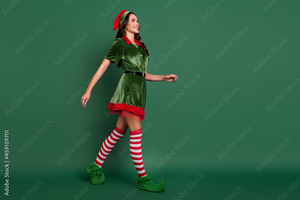 Wall mural Full length body size view of attractive cheerful girl elf going festal occasion time isolated over green color background