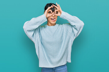 Fototapeta premium Young hispanic woman wearing casual clothes doing ok gesture like binoculars sticking tongue out, eyes looking through fingers. crazy expression.