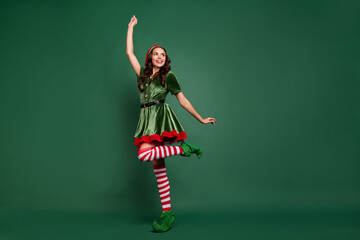 Full length body size view of attractive cheerful girl elf dancing rejoicing isolated over green...