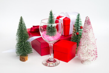 New Year's green Christmas tree in a wine glass red gift boxes. Christmas Greeting Card