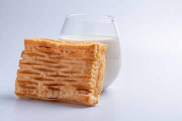Pineapple pie with fresh milk in a clear glass on a white background.