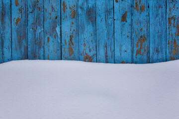 blue wood texture background with untouched snow, peeling paint on wood in winter