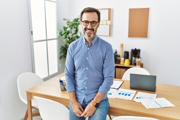 Middle age hispanic man with beard wearing business clothes at the office with a happy and cool smile on face. lucky person.