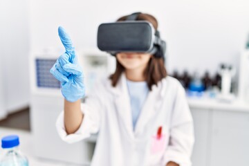 Young hispanic girl wearing virtual reality glasses at laboratory