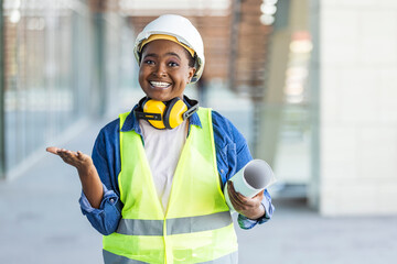 Female construction engineer. Architect with a blueprints at a construction site. Young Woman look in camera, building site place background. Portrait of adult female builder, engineer