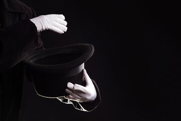 Hand gestures. illusionist holds a hat in his hands and shows magic and tricks.