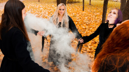 Coven of witches, modern witches gathered and do a ritual in the Park.