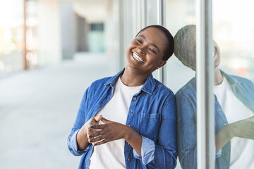 African american woman smiling and looking away. Outdoor portrait of a smiling black girl.  Smiling African American millennial woman posing outdoor, pretty positive female student