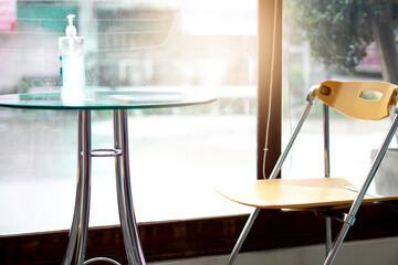 Yellow reception chair that was placed on the side. Glass table with a bottle of Alcohol placed on top. Corner for welcoming guests inside the building.