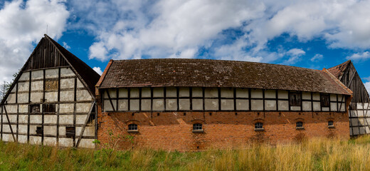 An old farmhouse made in the half-timbered technology. Photo taken in good lighting conditions on a sunny day.