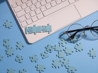 Puzzle elements on a laptop keyboard, software development, concept.