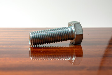 a few bolts and nuts on a polished wooden table