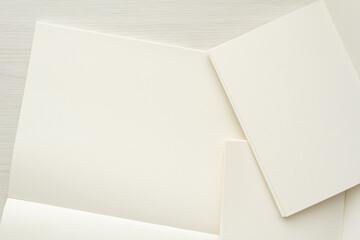 淡い木目の背景とコピースペースのある大小の白いノート