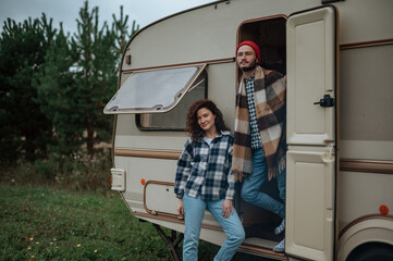 Romantic couple spending time together near trailer home. Traveling together with motor home.