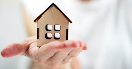 wooden house in the palm of a girl's hand, the concept of your own home