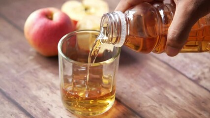pouring apple juice in a glass on table 