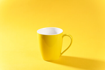 Yellow mug on yellow background.