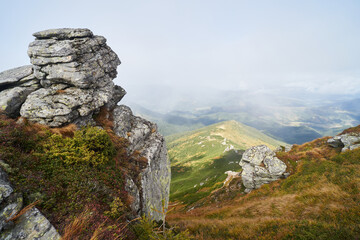 View from the top of the mountain to the stones and mountains in the fog