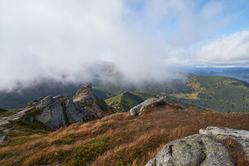 Mountain range in autumn in the clouds.  wild nature background