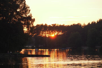 Zachód słońca nad wodą przy jeziorze - obrazy, fototapety, plakaty