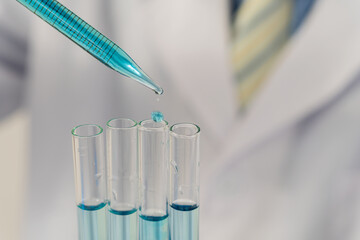 The pipette lowers the sample into the test tube. close-up concepts of genetic research and biological sciences human biology and pharmaceutical technology on laboratory background