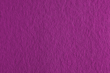The surface of vivid violet cardboard. Paper texture with cellulose fibers. Background with bright expressive tint. Paperboard wallpaper. Dark pink textured backdrop. Top-down. Macro