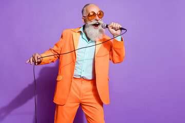Photo of old funny funky cool man sing mic karaoke good mood enjoy isolated on purple color...