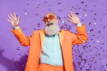 Photo of cheerful positive joyful cool old man confetti fall look copyspace dream isolated on...