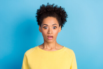 Photo portrait curly woman staring amazed shocked wearing yellow shirt isolated pastel blue color background