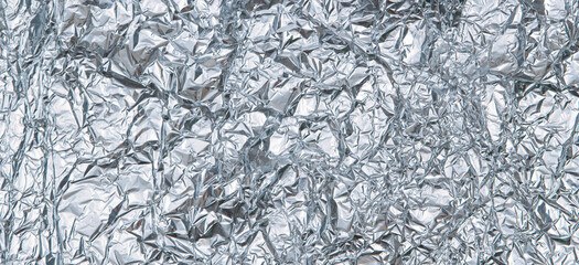 Silver shiny crumpled foil texture background. Top view