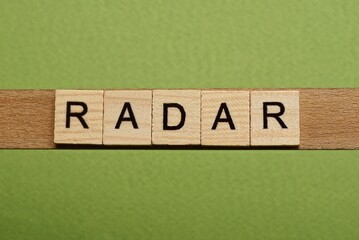 gray word radar from small wooden letters on a green table