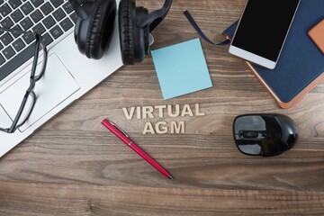 VIRTUAL AGM phrase from wooden font on the wooden table with office equipment