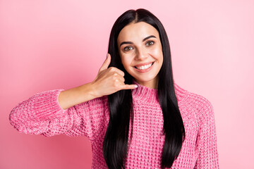 Photo of adorable cheerful young girl arm finger show phone call me symbol isolated on pink color background