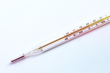 Glass medical mercury thermometer for measuring fever temperature show 39.1 Celsius and 102.2 Fahrenheit.