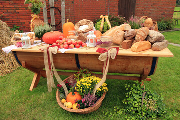 Erntedank, gesund ern&auml;hren: Regionale Nahrungsmittel sind auf einem schweren Holztisch im Garten aufgebaut
