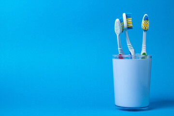 Toothbrushes on a blue background. Caring for the health of the oral cavity. Personal hygiene. There is a place for an inscription or logo