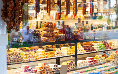 In front of store selling Turkish delight, various locum, arranged like pyramid, with knives, colorful sweets, ready to taste, in Spice bazaar Kemer.