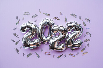 Banner. Happy New Year's Holiday. Balloons made of silver foil with the number 2022 and silver...