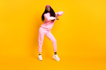 Fototapeta na wymiar Full size photo of optimistic funny girl dance look empty space wear pink costume headwear isolated on yellow color background