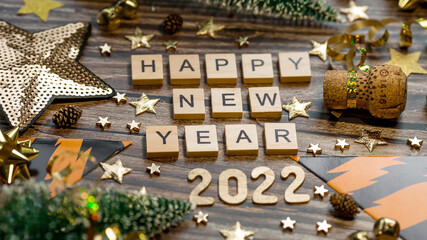 Fototapeta na wymiar Banner. A symbol from the number 2022 with golden balls, stars, sequins and tiger print on a wooden background. The concept of celebrating a Happy New Year and Christmas.
