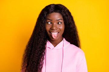 Photo portrait of african american funny woman showing tongue isolated on vivid yellow colored background